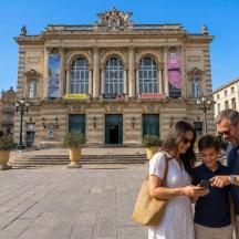 una famiglia che guarda un cellulare davanti a un edificio