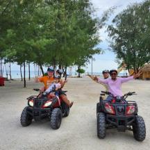 Eine Gruppe von Leuten, die mit Quads am Strand entlangfahren