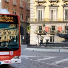 a red bus is driving down a city street