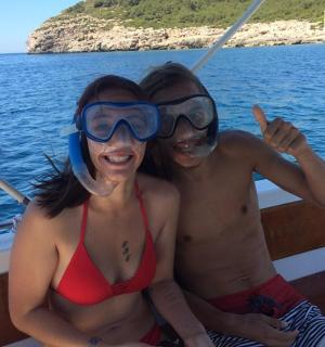 dua orang dalam pakaian mandi duduk di atas bot