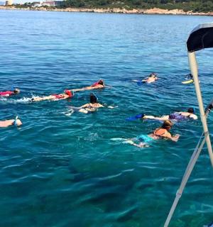 un gruppo di persone che nuotano nell'acqua su una barca