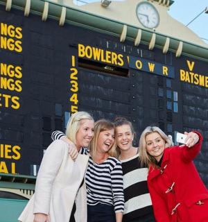 a group of people standing in front of a scoreboard