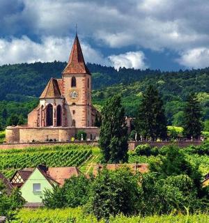 an old church with a clock tower on a hill