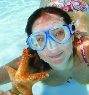 a woman in a swimming pool holding a starfish