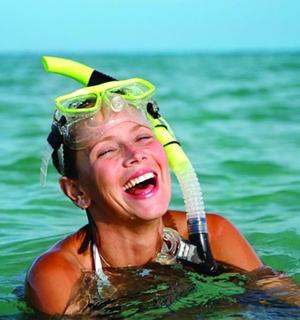 a young girl in the water wearing a hat and goggles