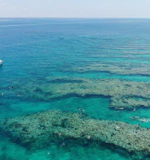 a boat floating in the ocean next to a reef