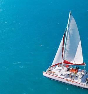 a boat with a white sail in the water