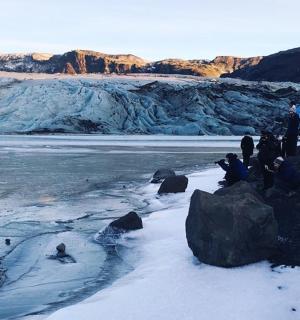 a group of people standing on a glacier in the snow