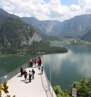 група људи који ходају преко моста преко језера