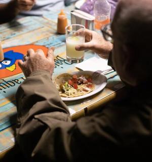 一群人坐在桌旁,桌上摆着一盘食物