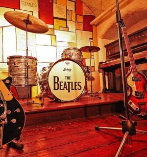 a room filled with guitars and a drum set