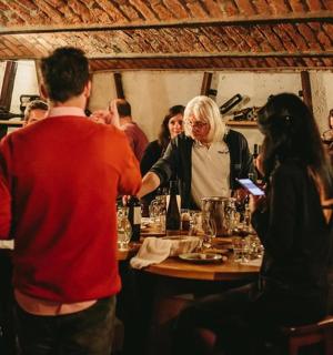 skupina lidí sedících kolem stolu v restauraci