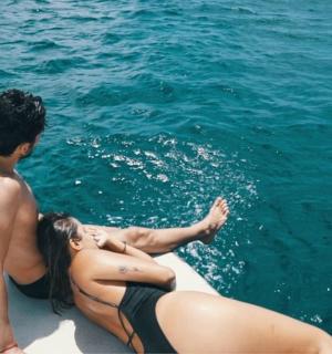 a man and a woman sitting on a boat in the water
