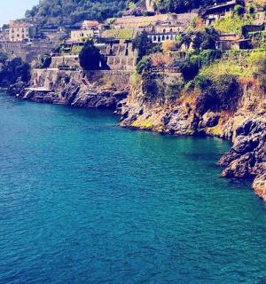 a large body of water with houses on a cliff