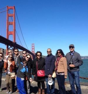a group of people standing in front of the golden gate bridge