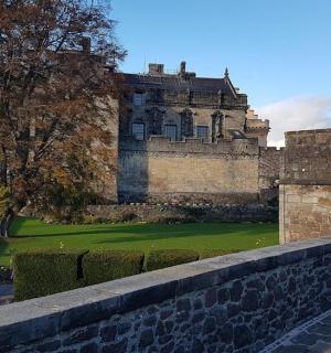 一座位于石墙后面、有绿色草坪的大城堡