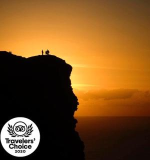 日落时站在山顶的人