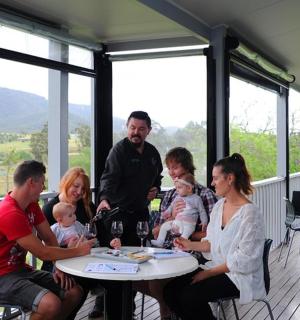 hópur fólks situr við borð á veröndinni