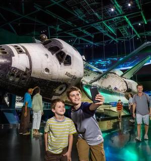 muž stojící před muzeem raketoplánů