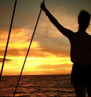 日落时站在船上的女人