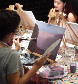 a woman is painting a painting on a table