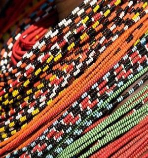 a close up of a colorful rug with beads on it