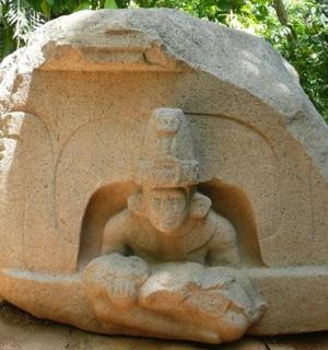 一名男子坐在岩石上的雕像