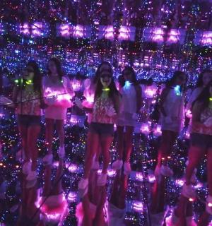 a group of girls standing in front of lights