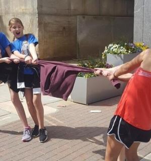 three girls are holding up a blanket