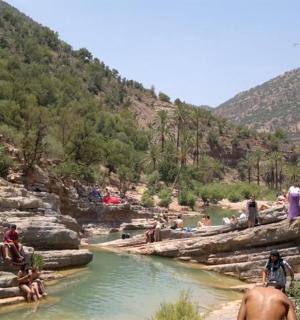a group of people sitting on rocks in a river