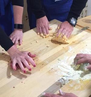 skupina lidí připravujících jídlo na dřevěném stole