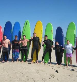 a group of people standing in front of their surfboards