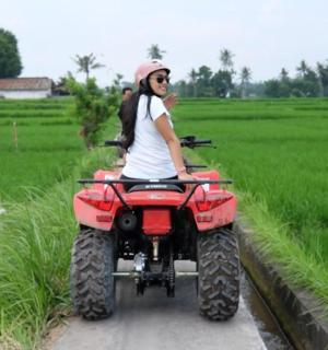 žena jedoucí na čtyřkolce v poli