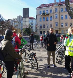 a group of people standing on a sidewalk with bikes