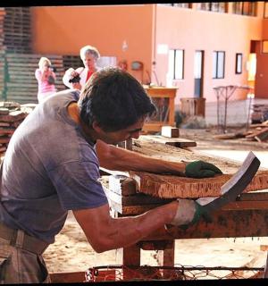 a man working on a table with a large knife