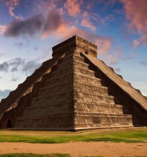 una piràmide amb un cel ennuvolat al fons