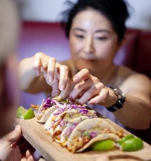a woman is holding a plate of food