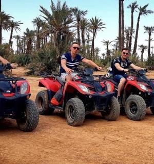 skupina mužů jedoucích na čtyřkolkách na prašném poli