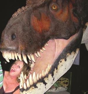 žena a dítě stojící vedle kostry dinosaura