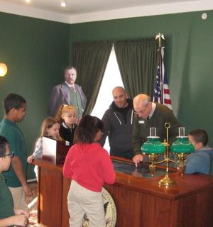 skupina lidí stojících kolem stolu se svíčkami