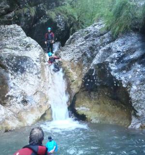 skupina lidí stojící před vodopádem