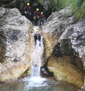skupina lidí stojící na skále poblíž vodopádu