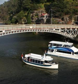 two boats in the water under a bridge