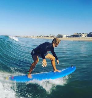 muž jedoucí na vlně na surfovém prkně v oceánu