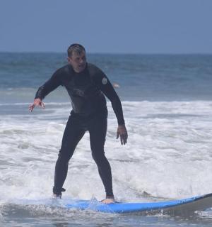 muž jedoucí na vlně na surfovém prkně v oceánu