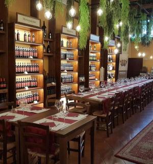 a restaurant with a long table in a room with wine bottles