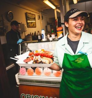 一名男子站在厨房里,托盘上放着食物