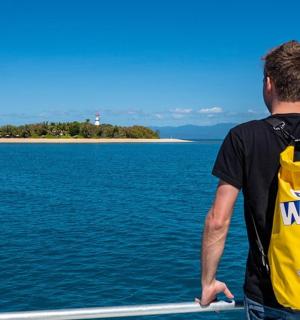 一名身穿黄色背心的男子眺望大海