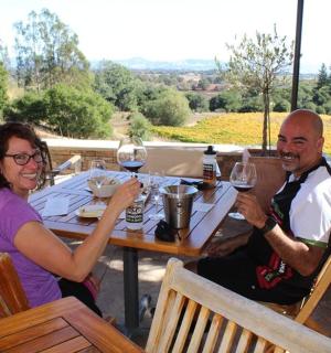 一男一女坐在桌边，手里拿着酒杯