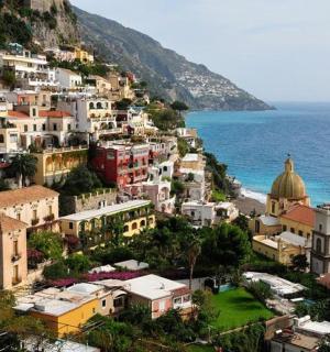 a group of buildings on a hill next to the ocean